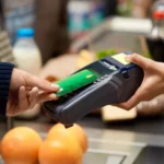 making a contactless payment at a point-of-sale (POS) terminal in a store. black people